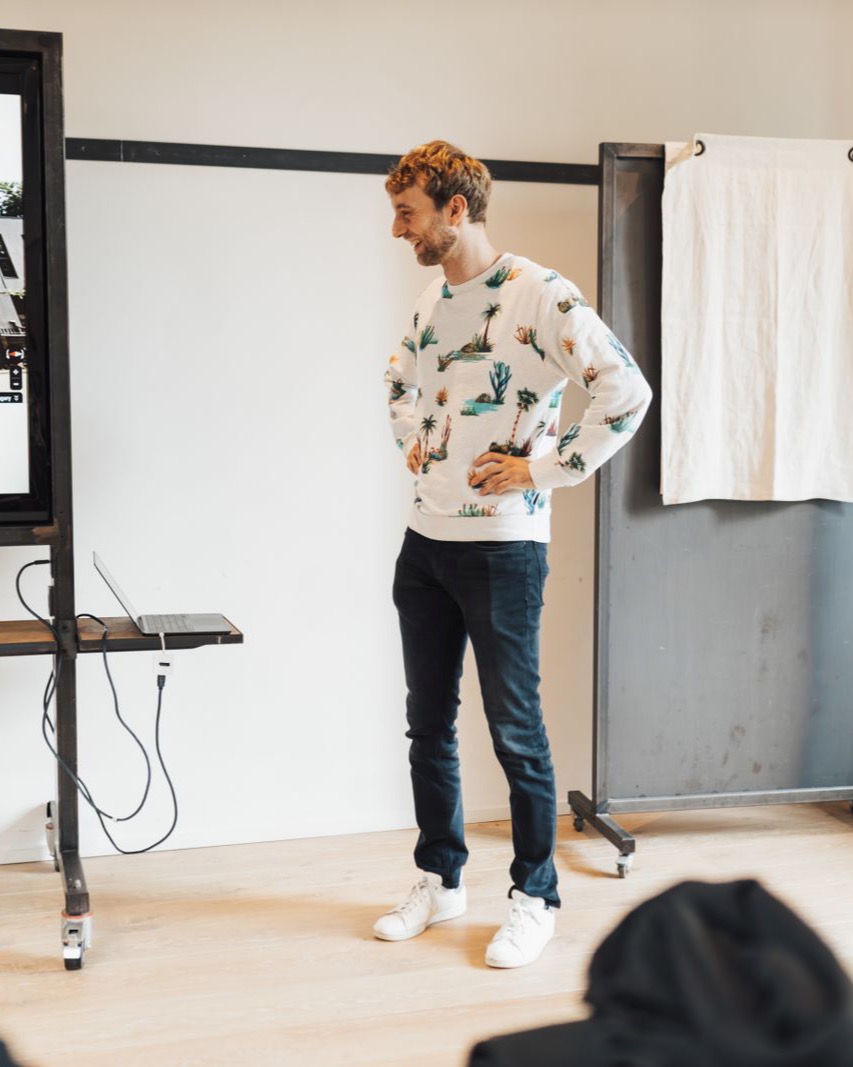 A presenter speaking to an engaged audience in a bright modern room